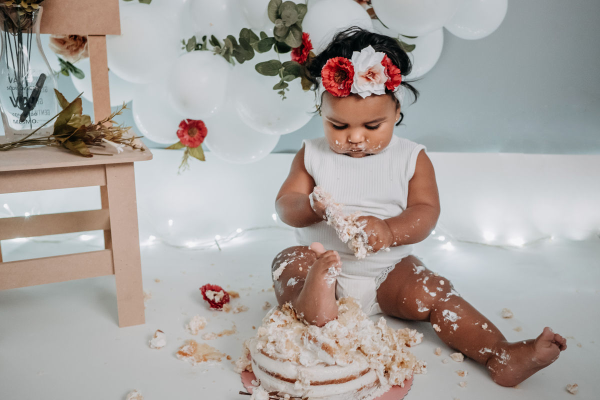 bebê com pé em cima do bolo