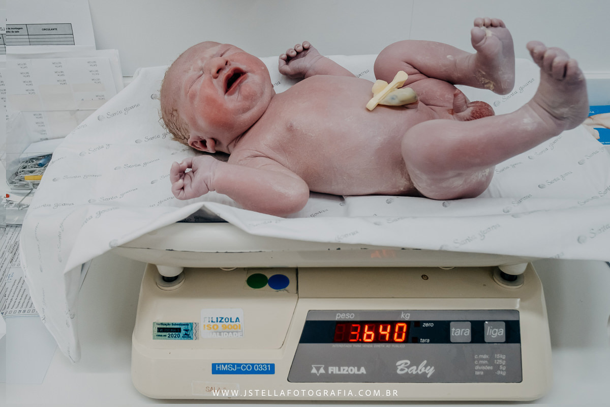 recém nascido sendo pesado