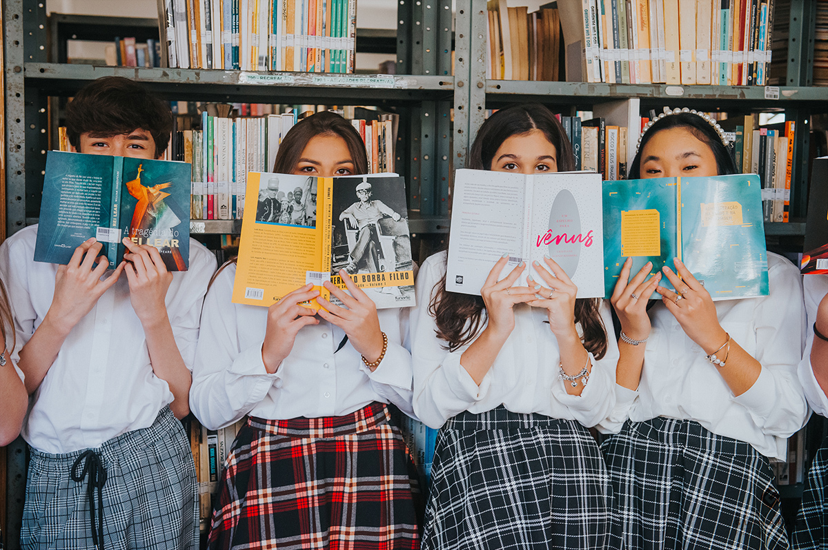 Foto com amigos
 segurando os livros no rosto