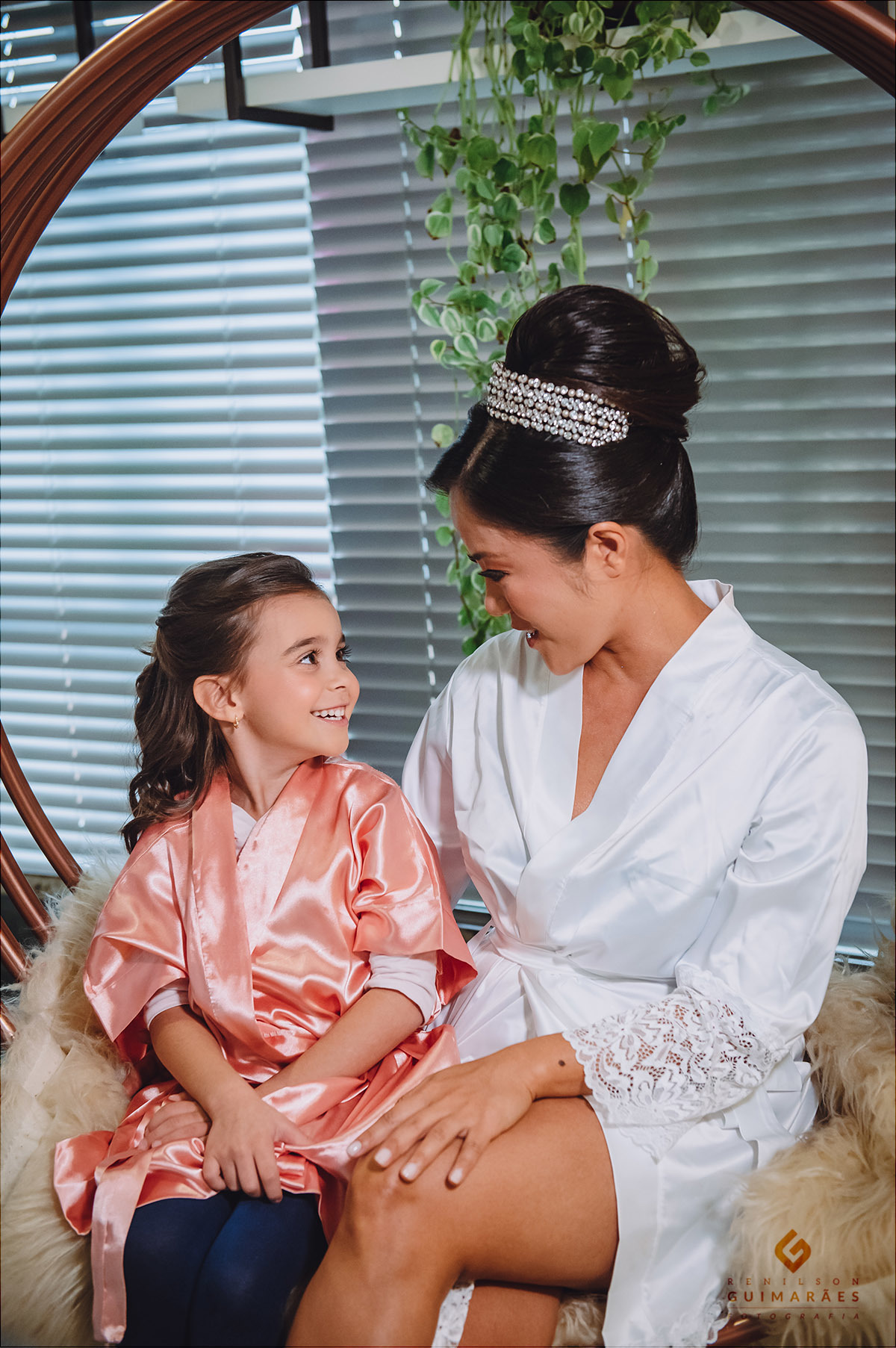 A daminha e a noiva sentadas em um balanço