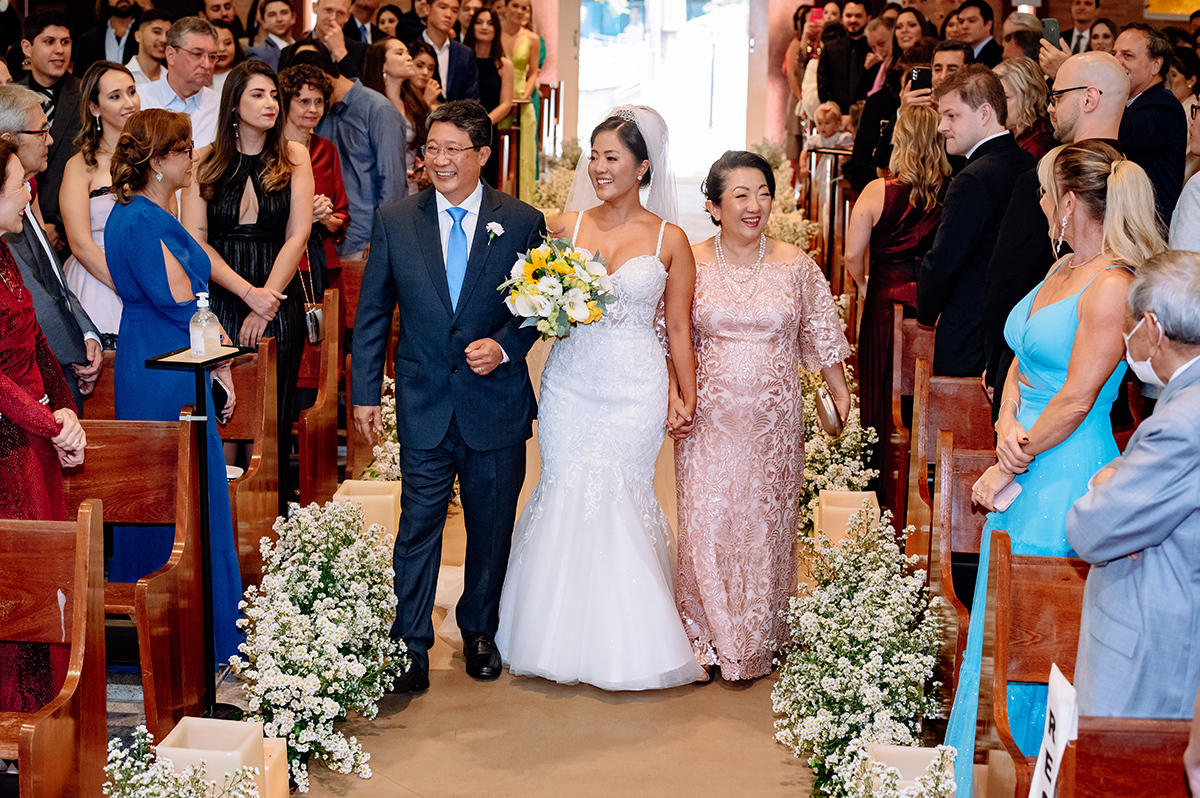 Foto da noiva entrando com os pais no casamento
