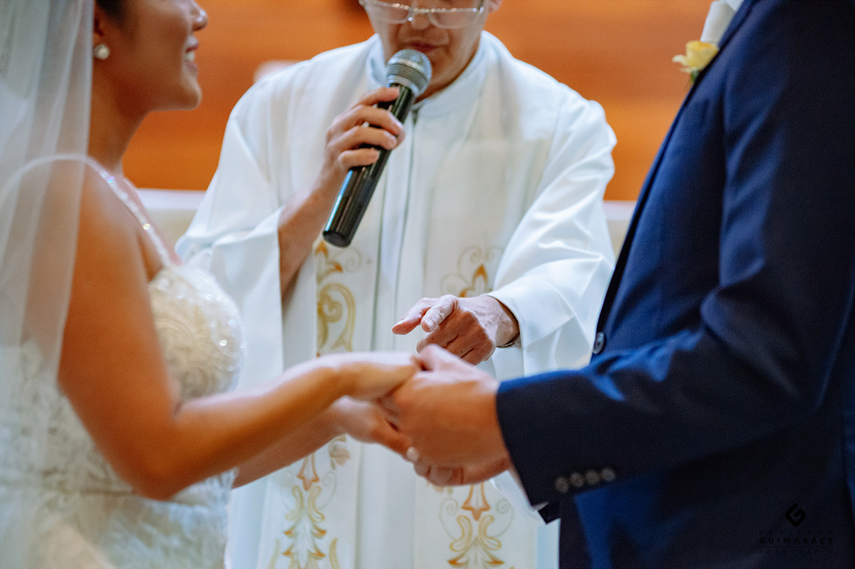O padre indicando as mãos dos noivos