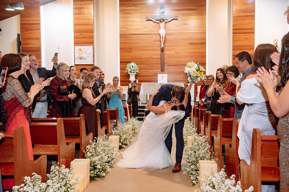 O beijo dos noivos no corredor da igreja