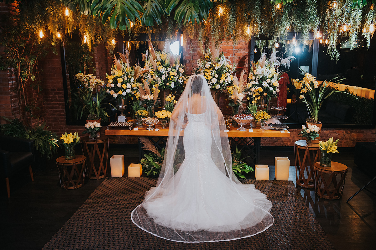 Foto da noiva de costas na mesa de doces