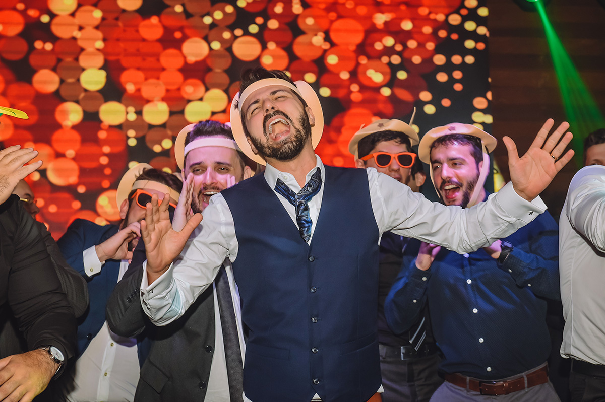 O noivo cantando com os amigos no palco do casamento