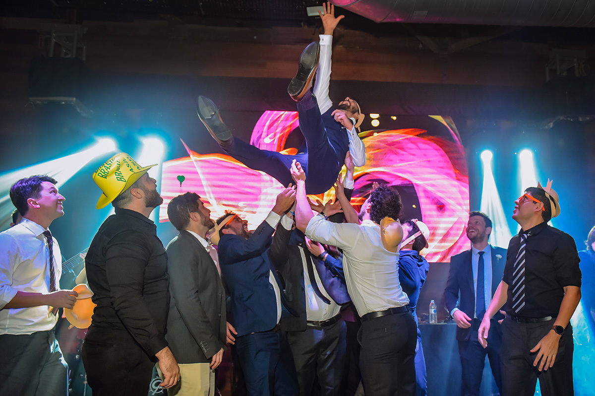 Os amigos do noivo jogando ele pra cima