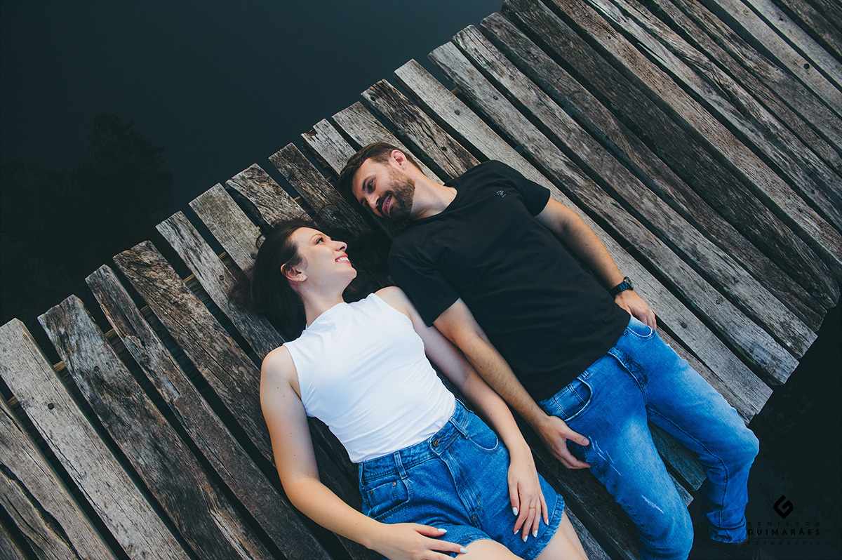 Fotos dos noivos deitados na passarela de madeira