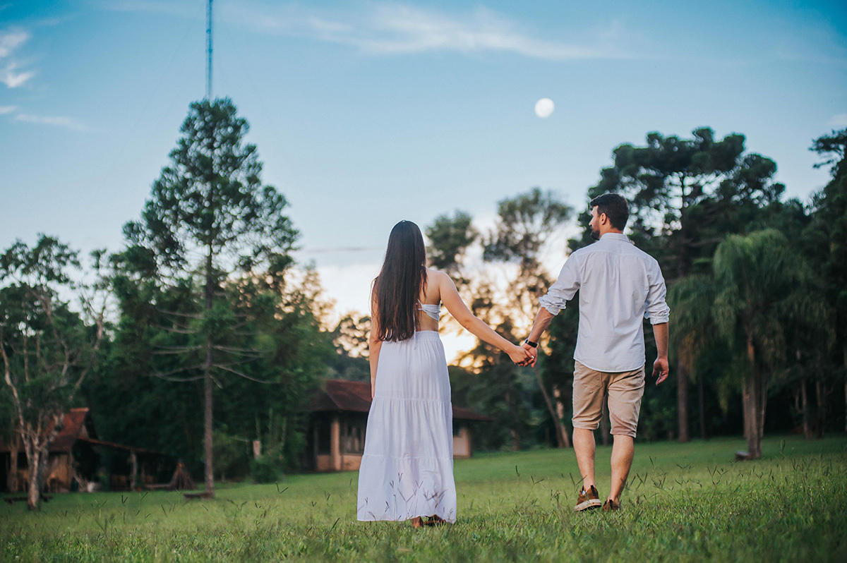Casal caminhando com a lua de frente