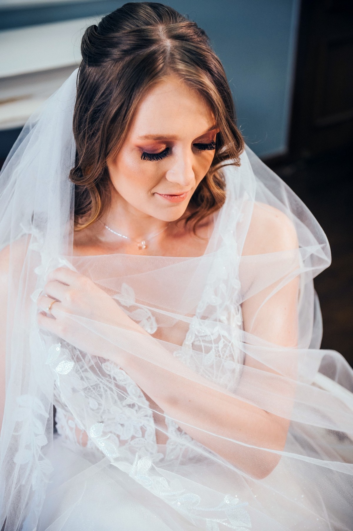 Foto da noiva segurando o véu no salão de beleza