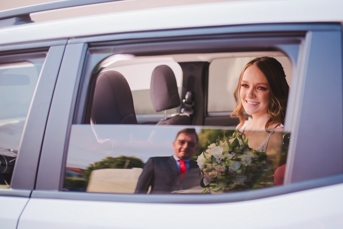Foto do reflexo do pai da noiva no carro da noiva 