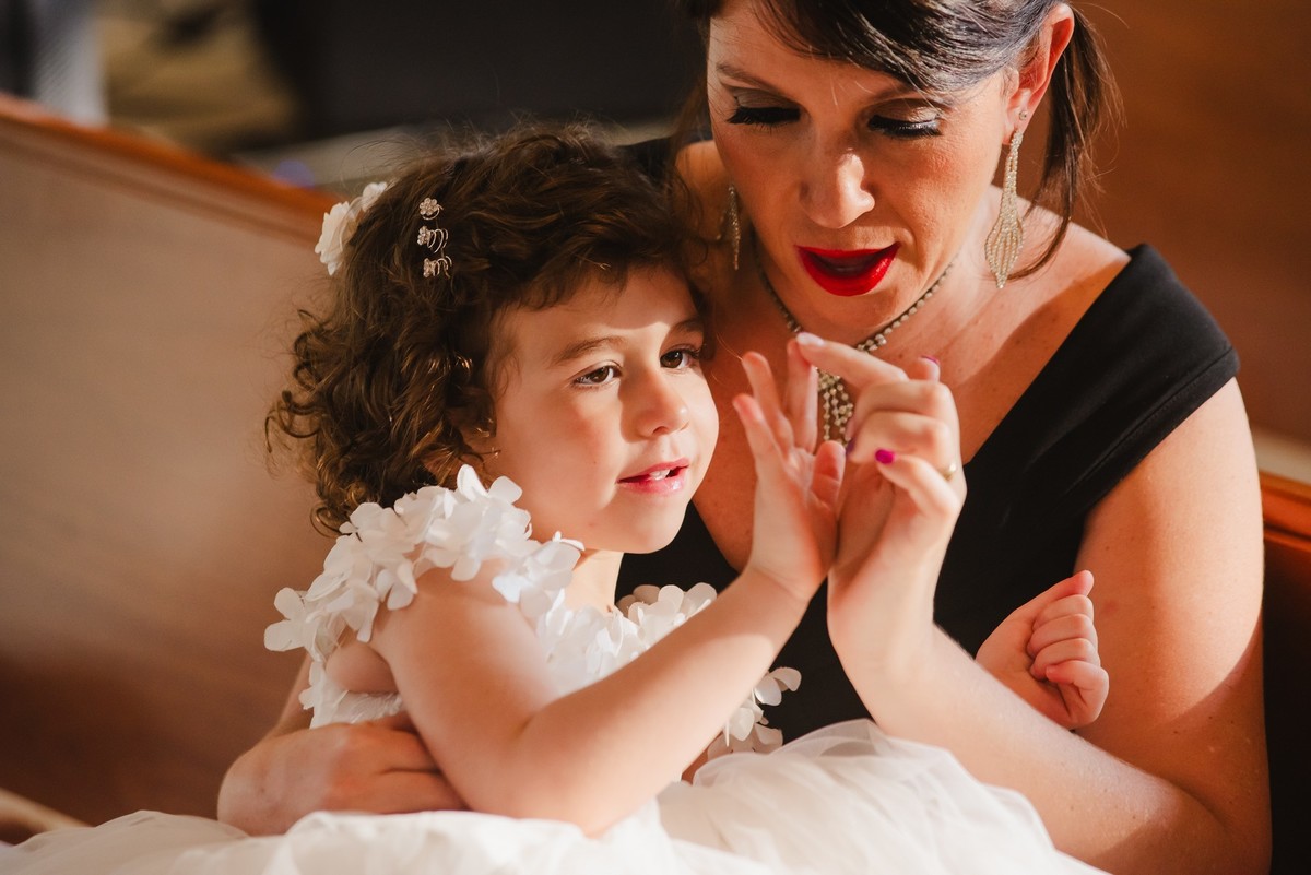 a daminha brincando com os dedos com a mamãe