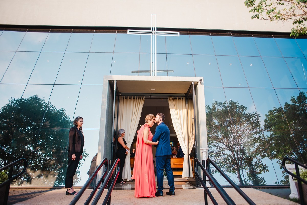 A mãe dando um beijo no noivo na porta da igreja