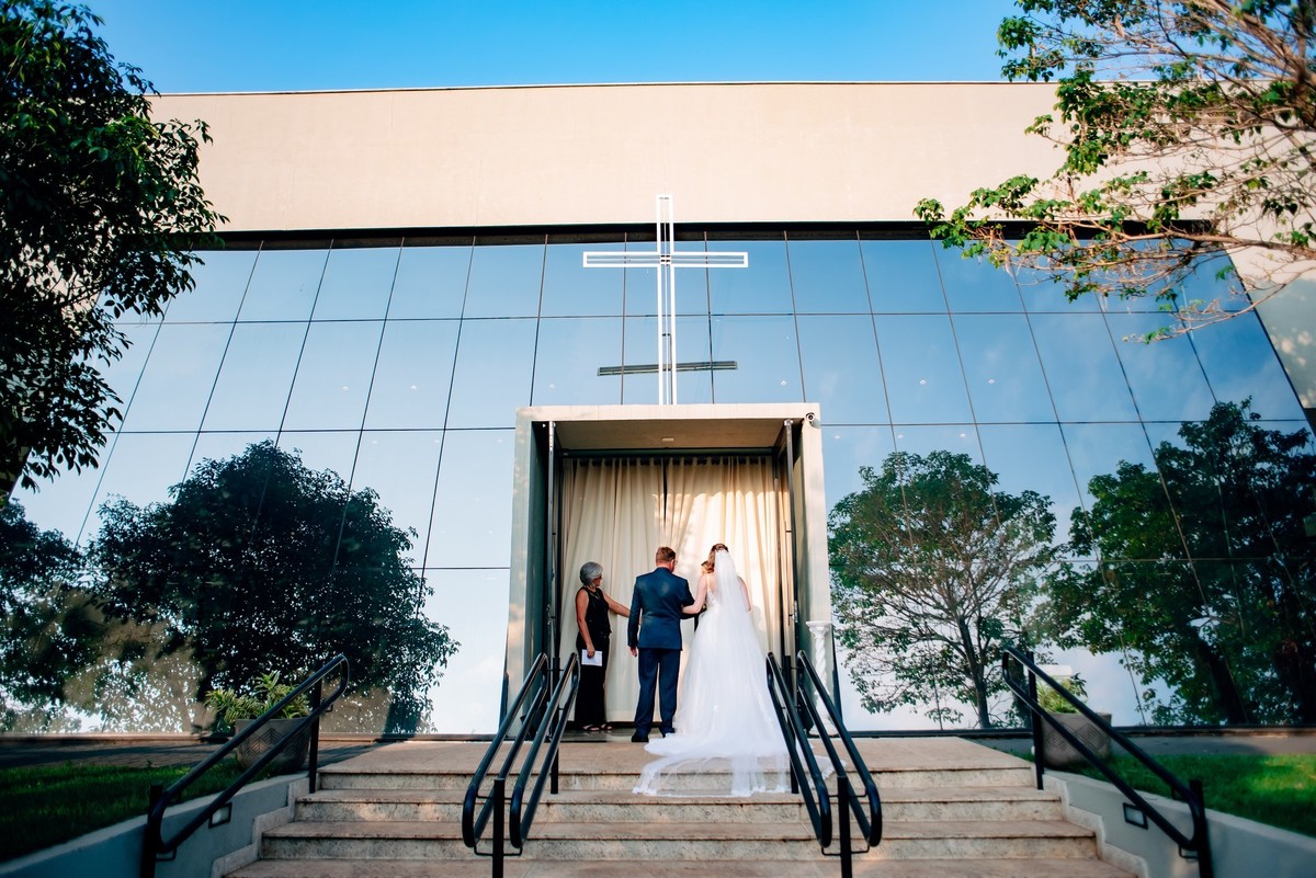 A noiva com seu pai de costas na porta da igreja
