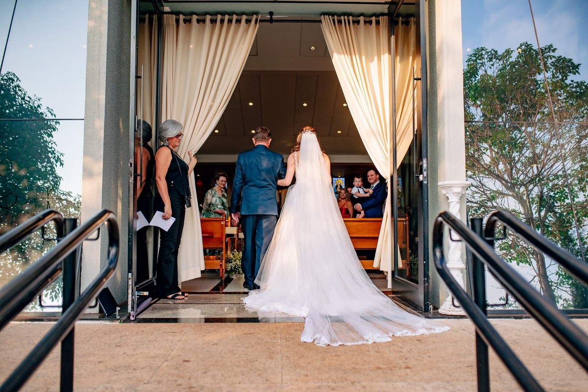 A noiva entrando na igreja com o seu pai