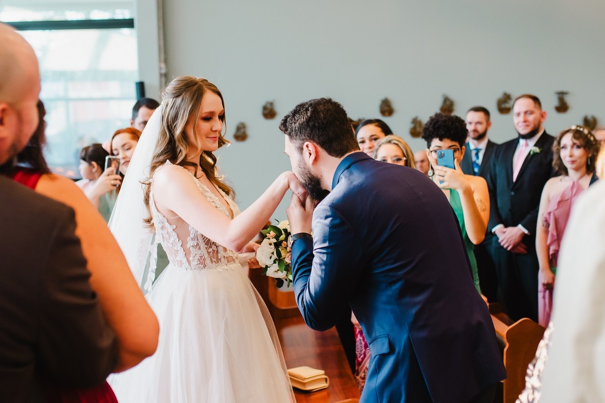 O noivo beijando a mão da noiva