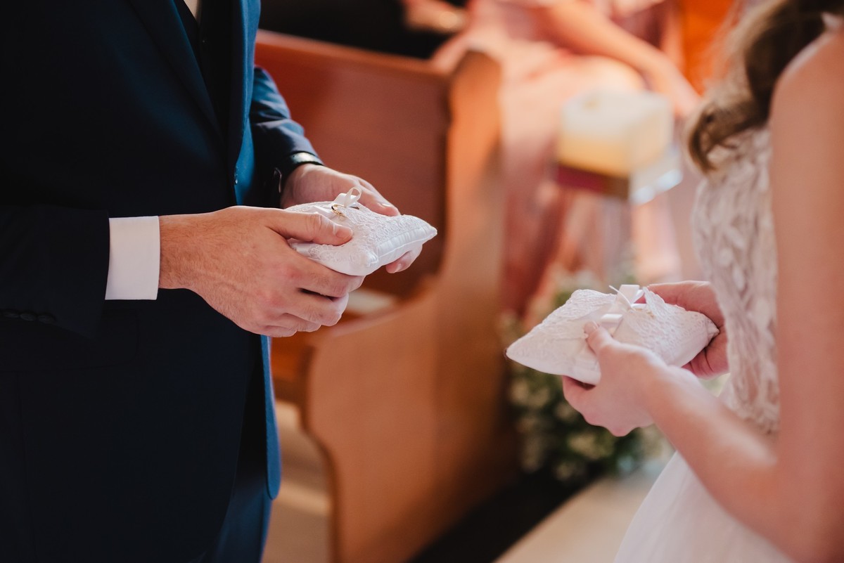 Os noivos segurando as alianças