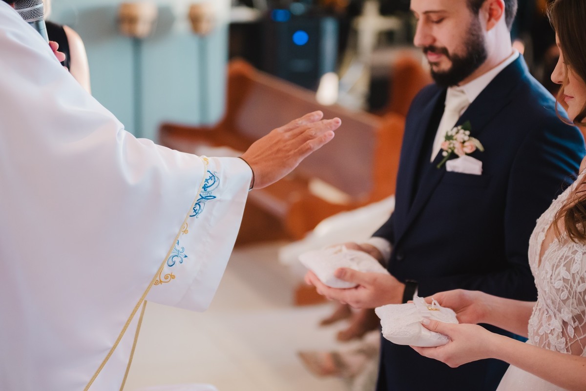 o padre abençoando as alianças