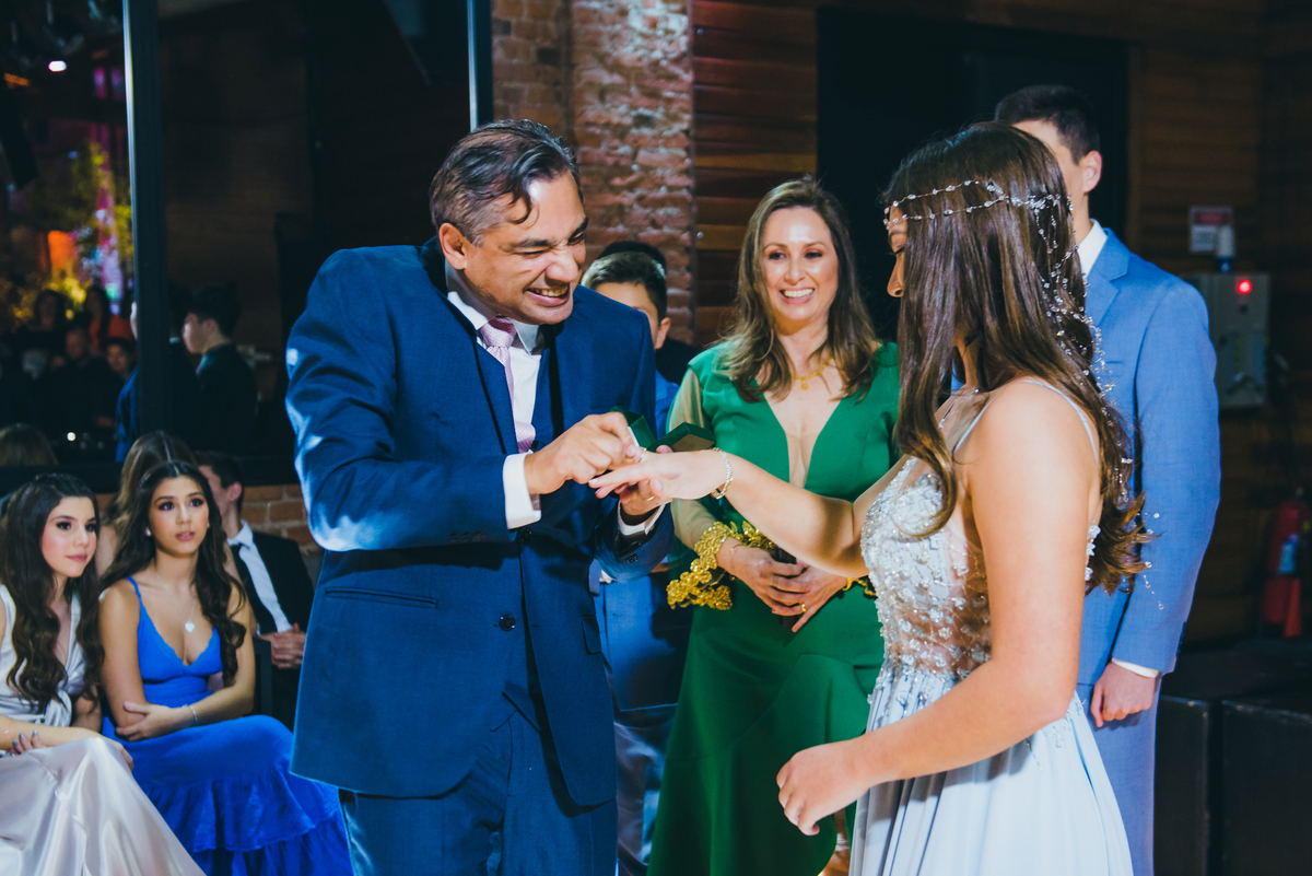 O pai colocando o anel na debutante
