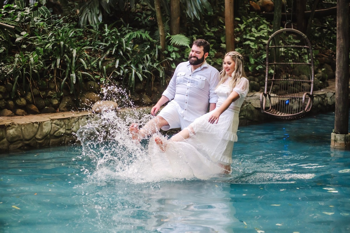 Casal chutando a água da piscina