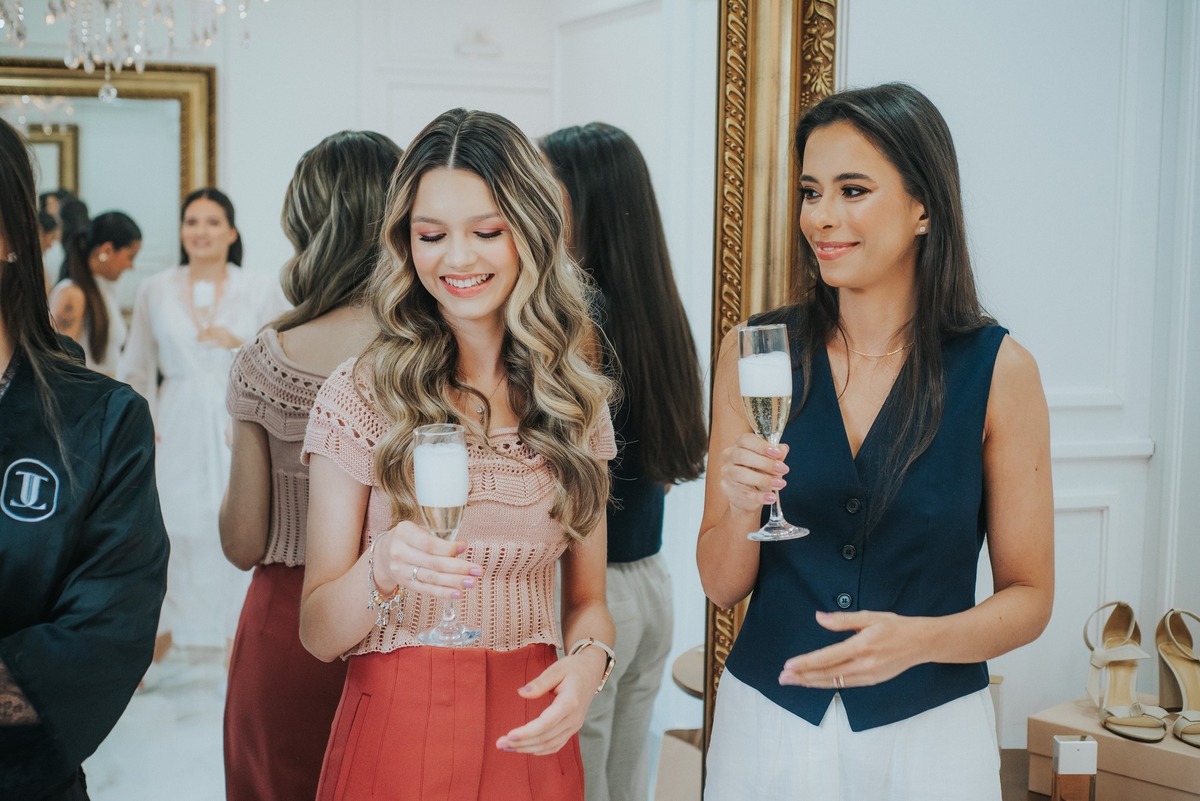 2 madrinhas com a taça de champanhe na mão