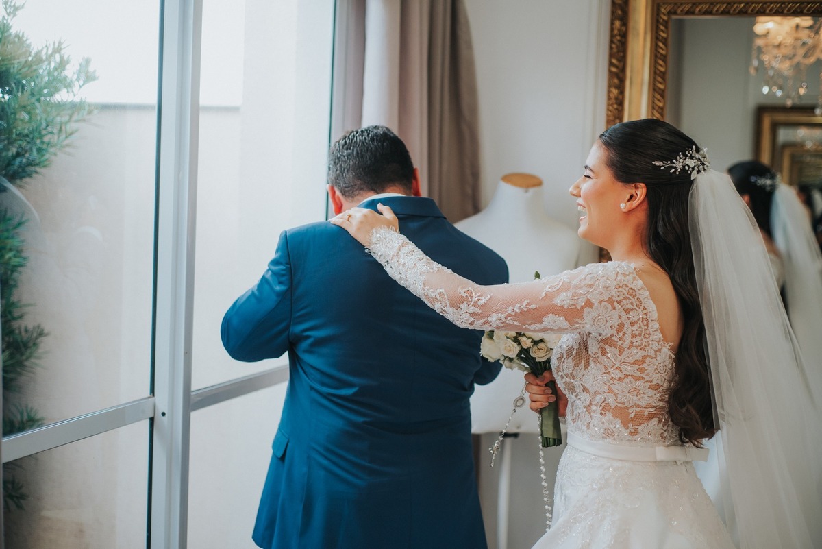 A noiva colocando a mâo no ombro do pai