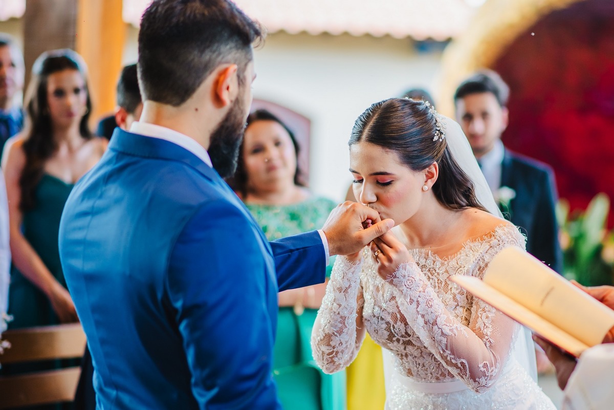 Noiva beijando a aliança do noivo