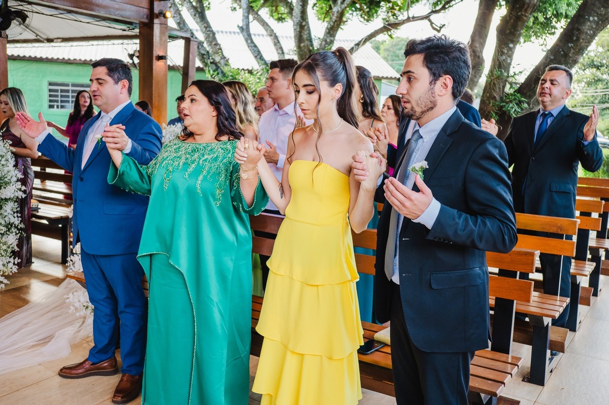 Convidados de mãos dadas rezando o pai nosso