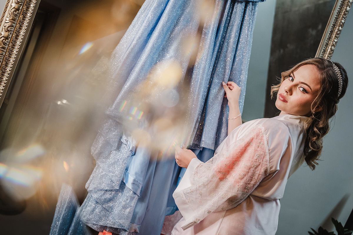 A aniversarinte segurando o seu vestido posando para a foto