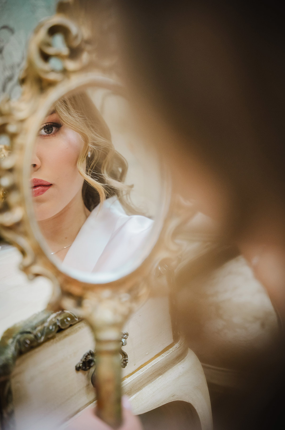 A debutante segurando o espelho olhando o seu reflexo