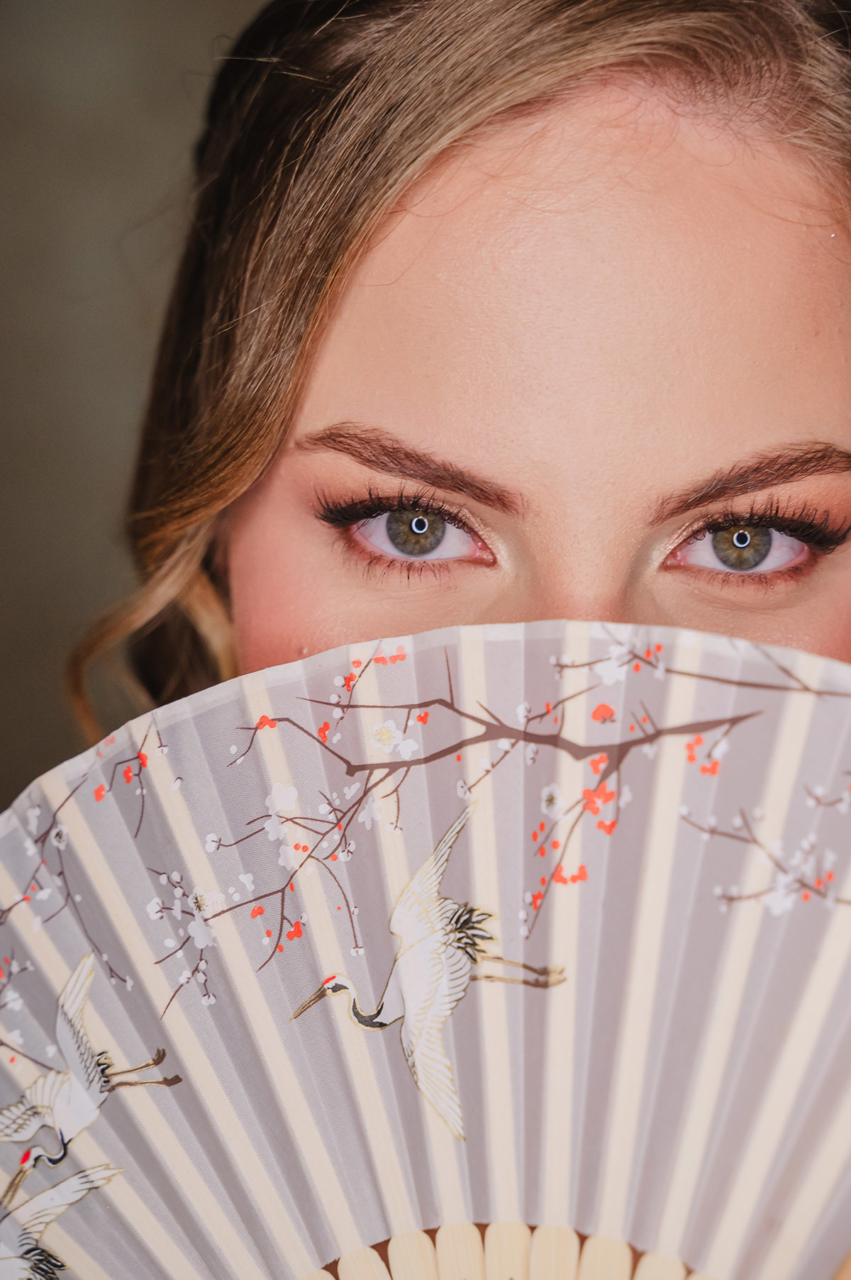 A debutante segurando o leque com os olhos claros acima dele