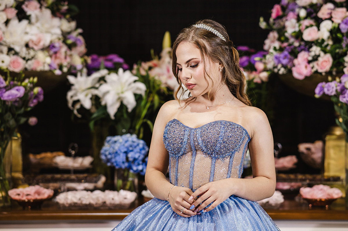 Foto da aniversariante em frente a linda mesa de doces