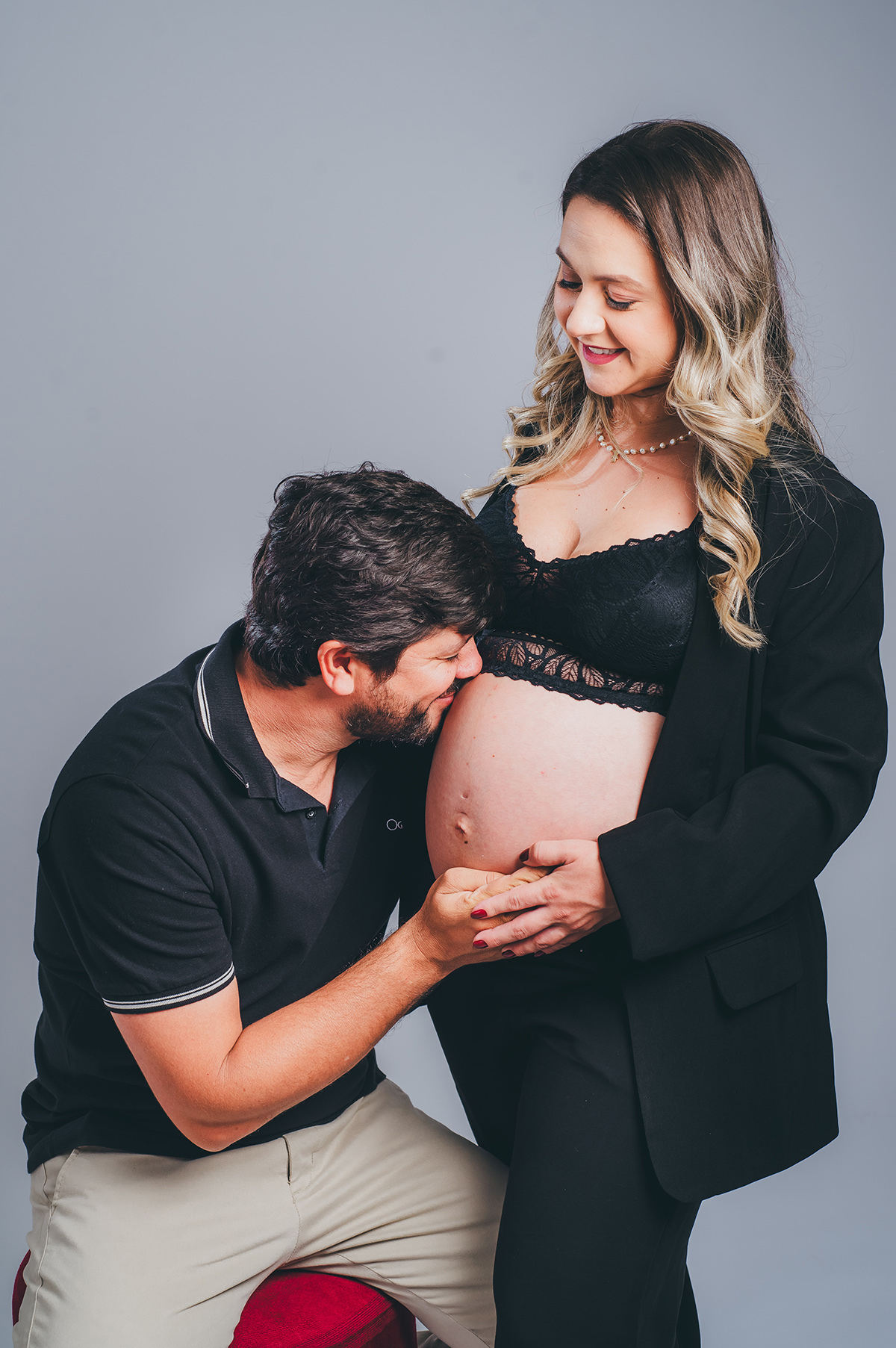 o pai dando um beijo na barriga da esposa gestante