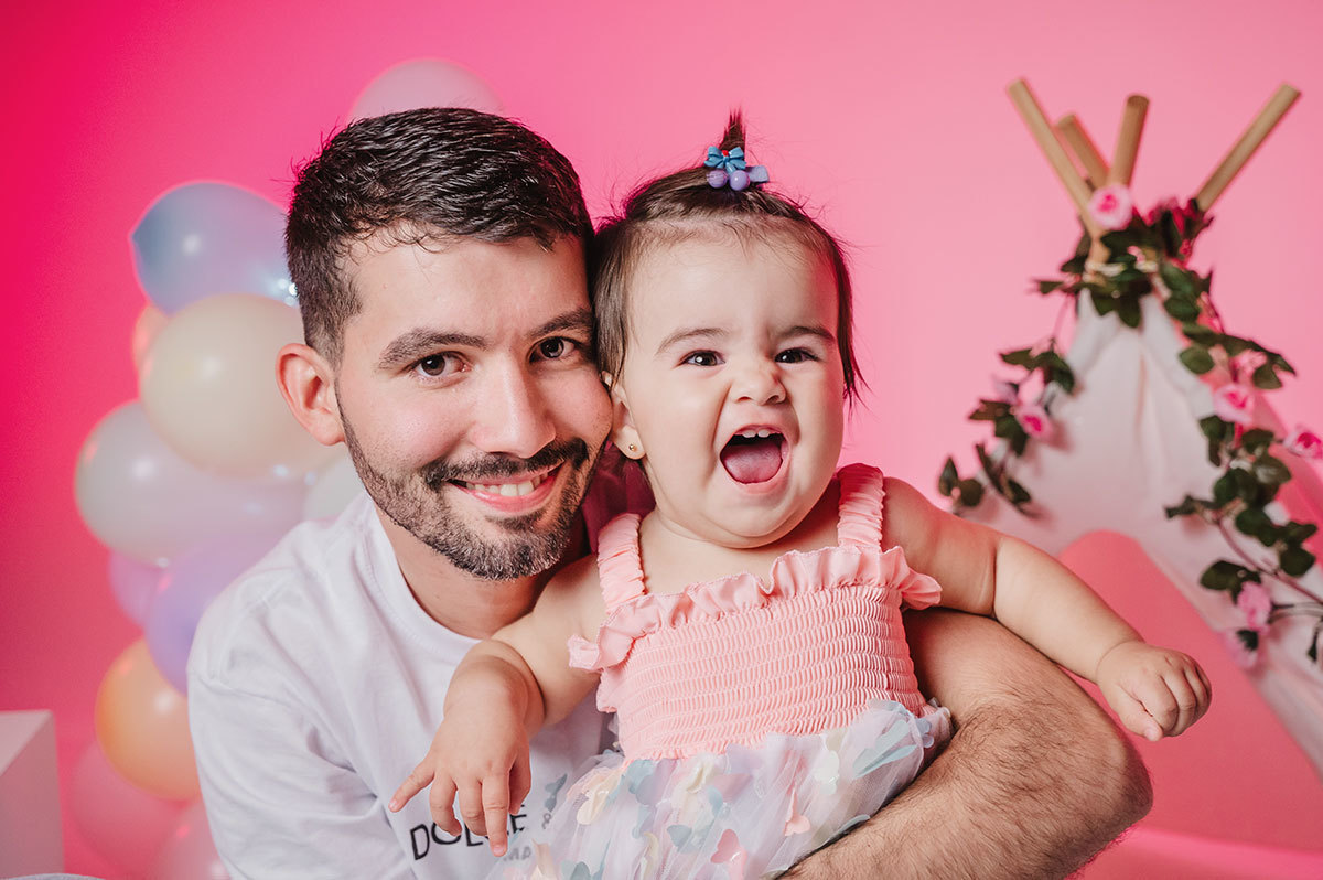 Foto da Lara sorrindo com o papai a abraçando