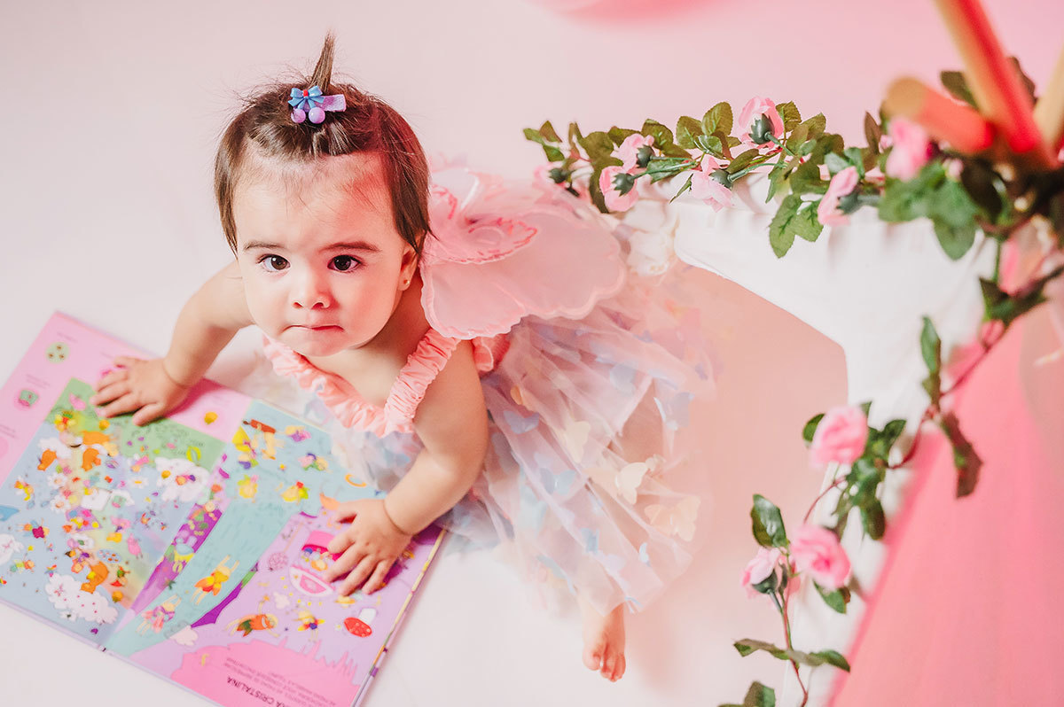 A Lara brincandocom um livro infantil, a cena mostrada de cima