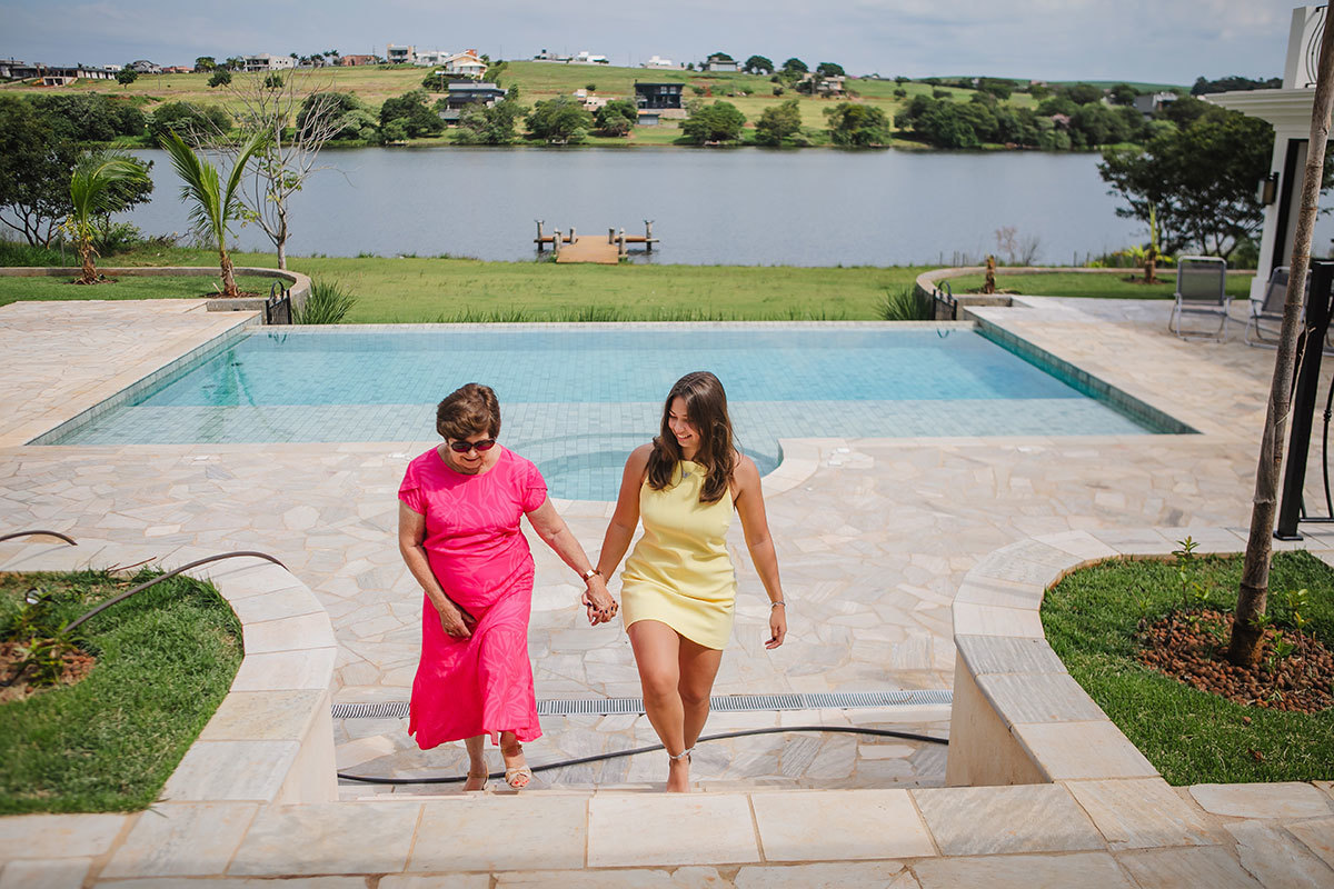 Vó e neta subindo as escadas na mansão
