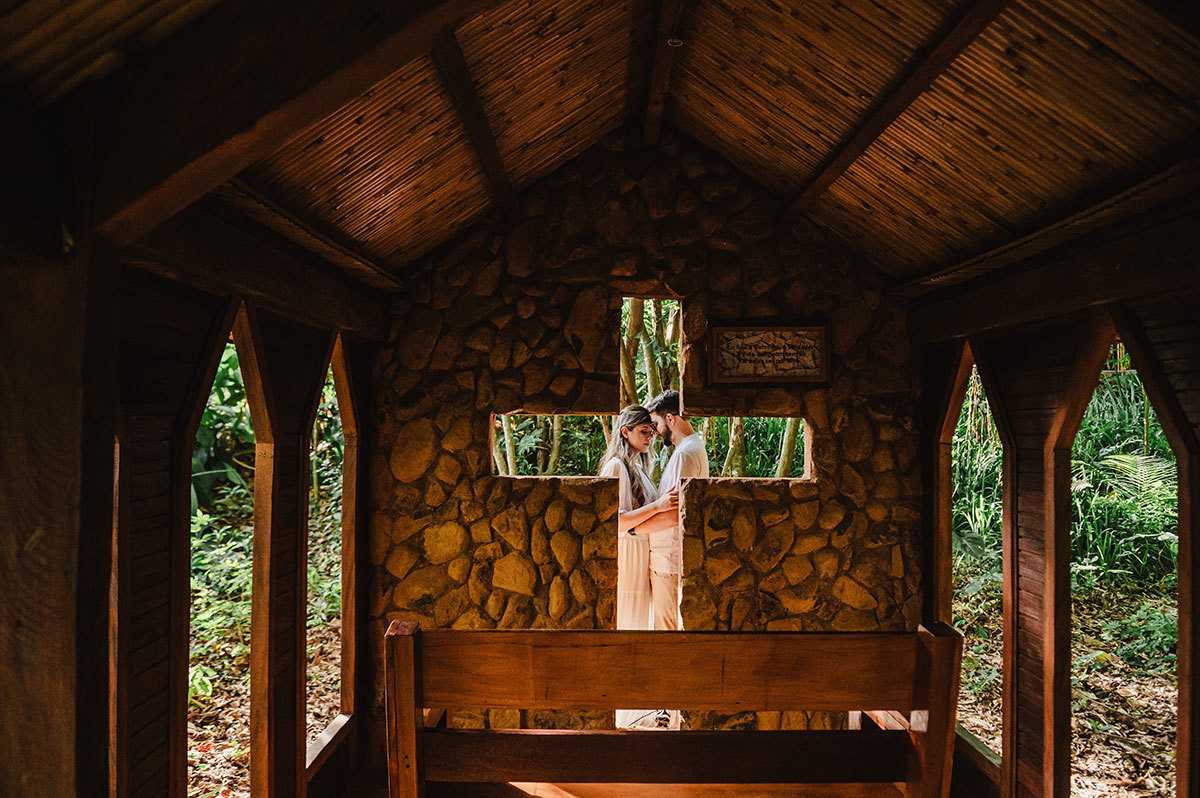 Foto dos noivos atras da cruz vazada