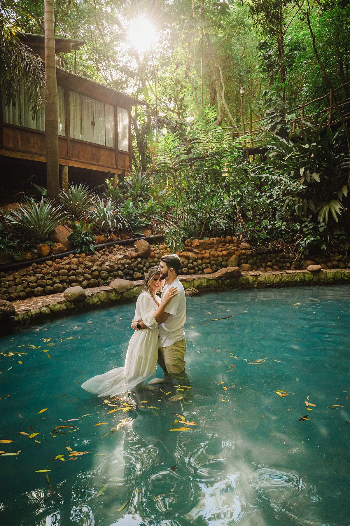 Noivos abraçados dentro da piscina