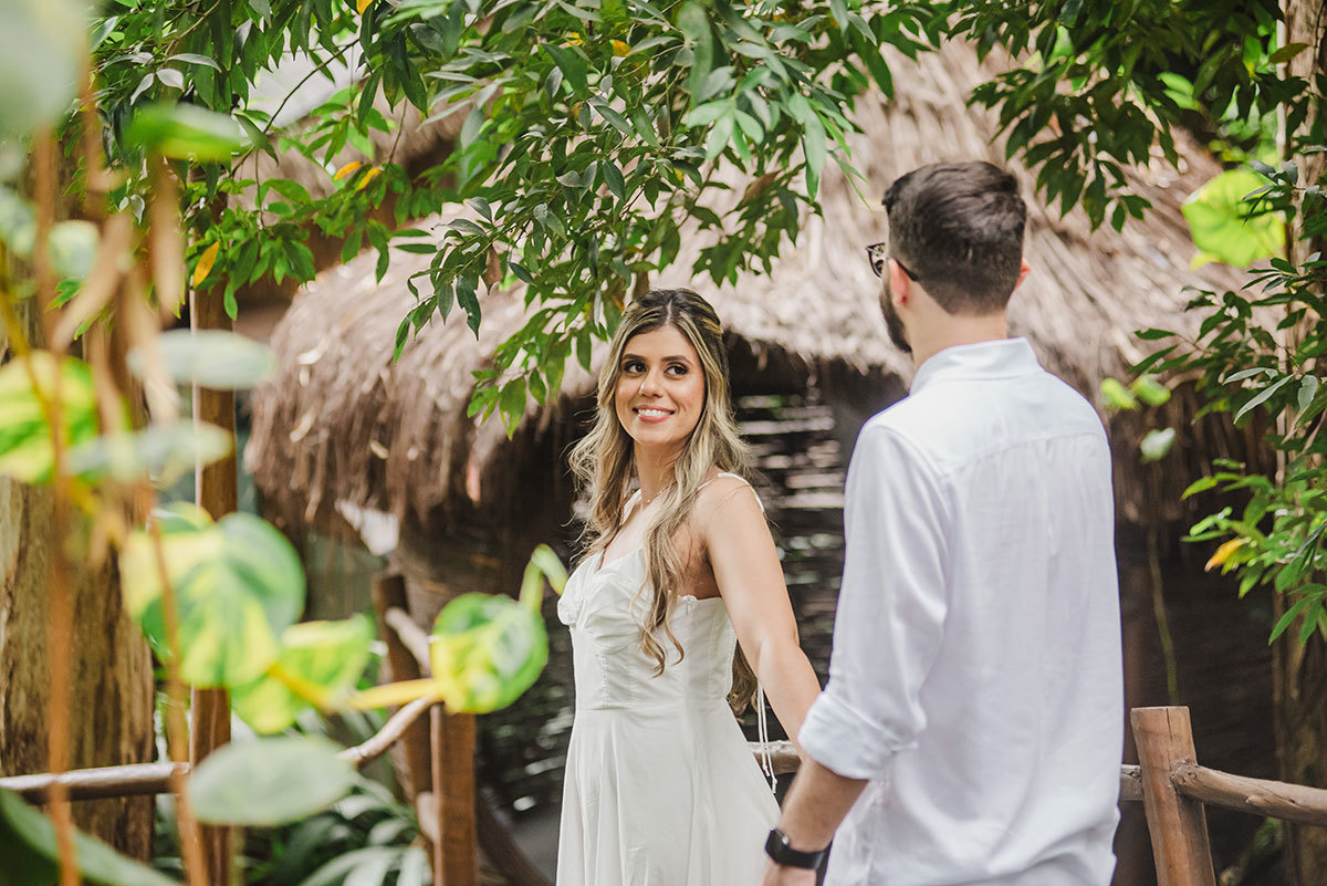 Noiva de mãos dadas com o noivo olhando pra ele