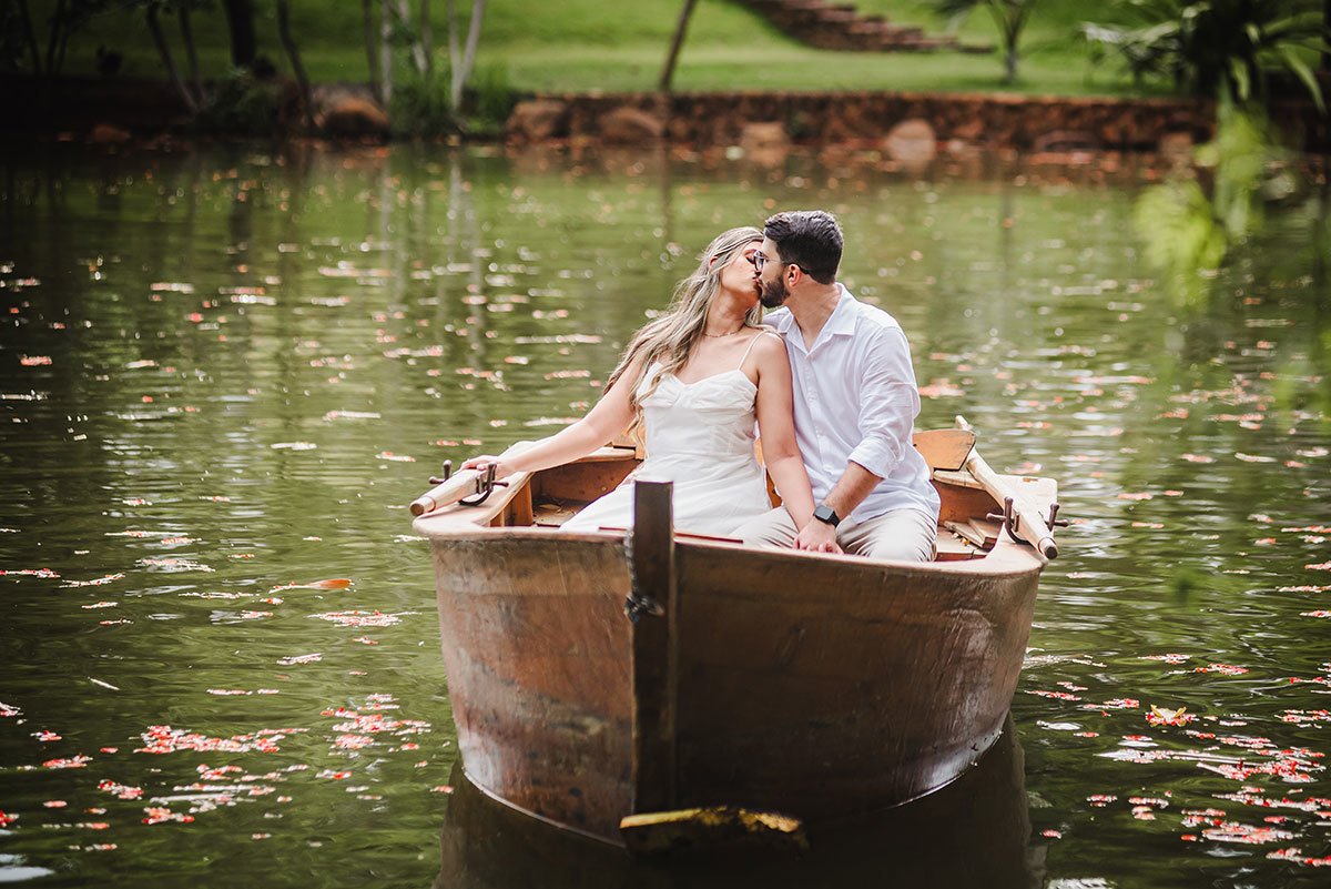 Noivos se beijando no barco em um lago tranquilo