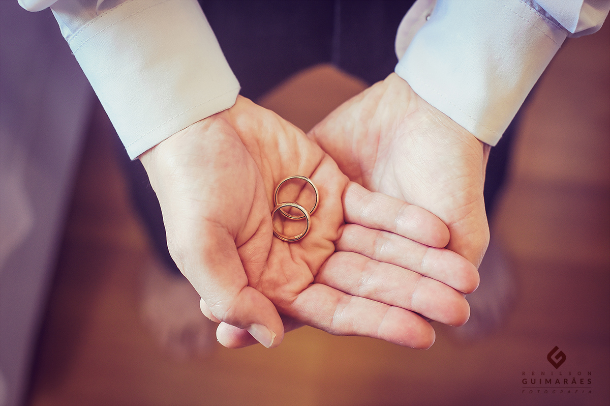 O noivo segurando as alianças