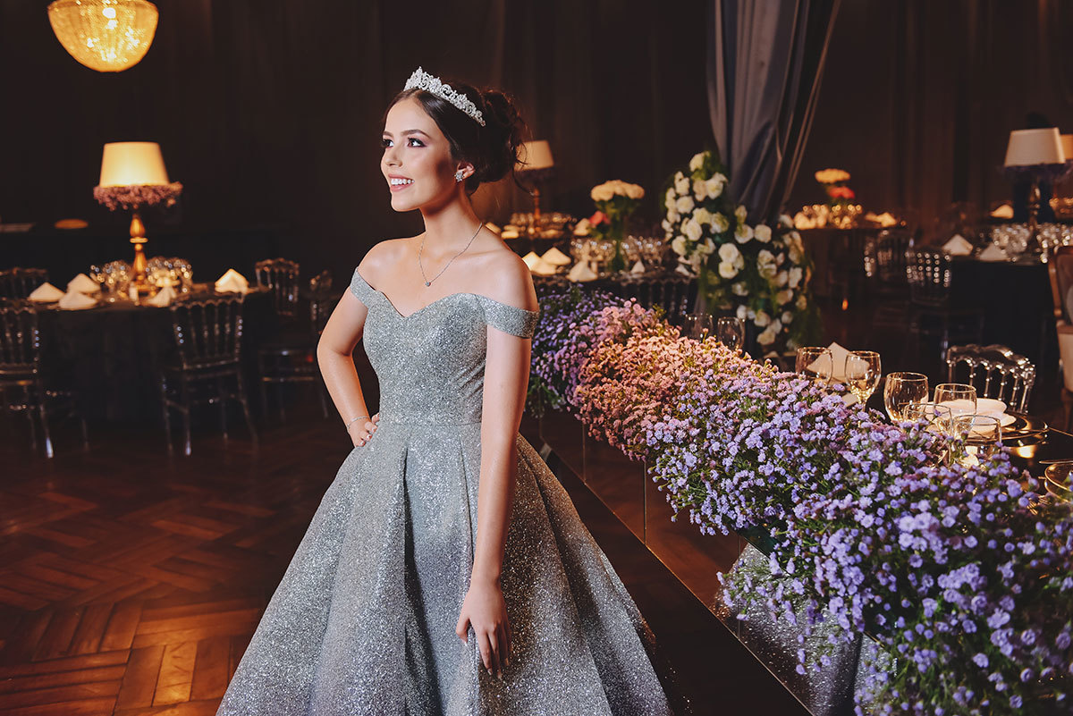 Foto da aniversariante na decoração com flroes roxas