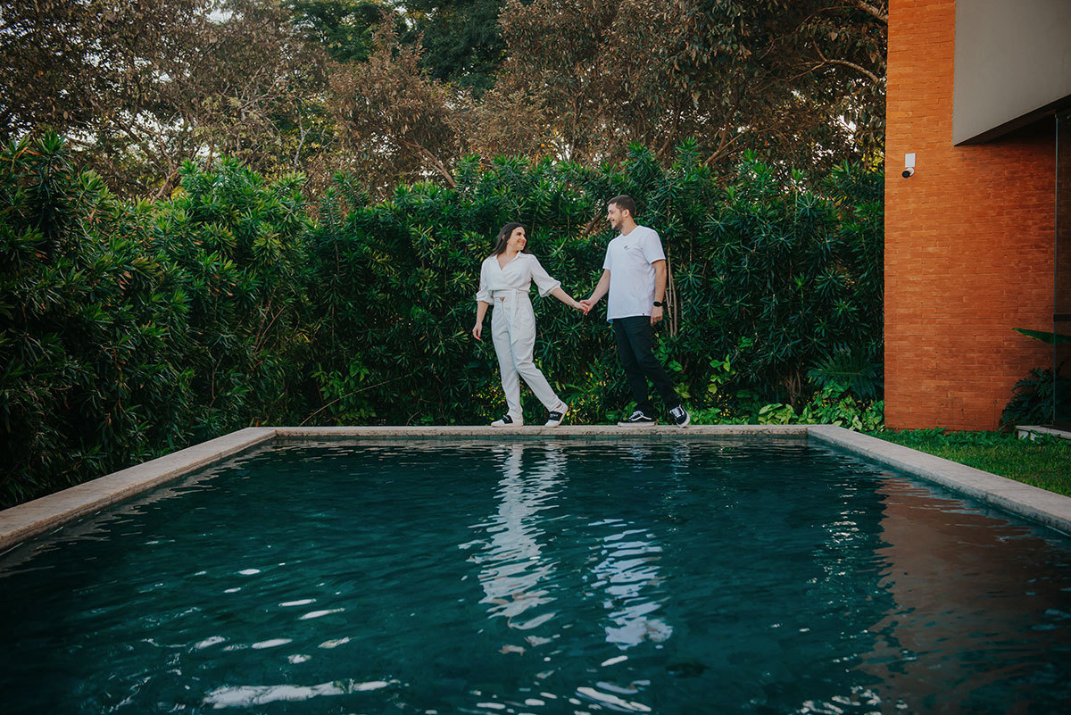 Casal andando na beira da piscina
