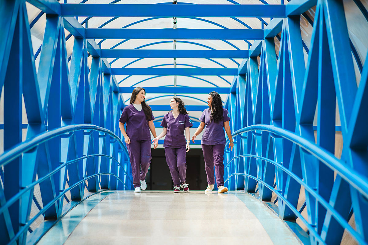 Três amigas residentes de fisioterapia andando conversando