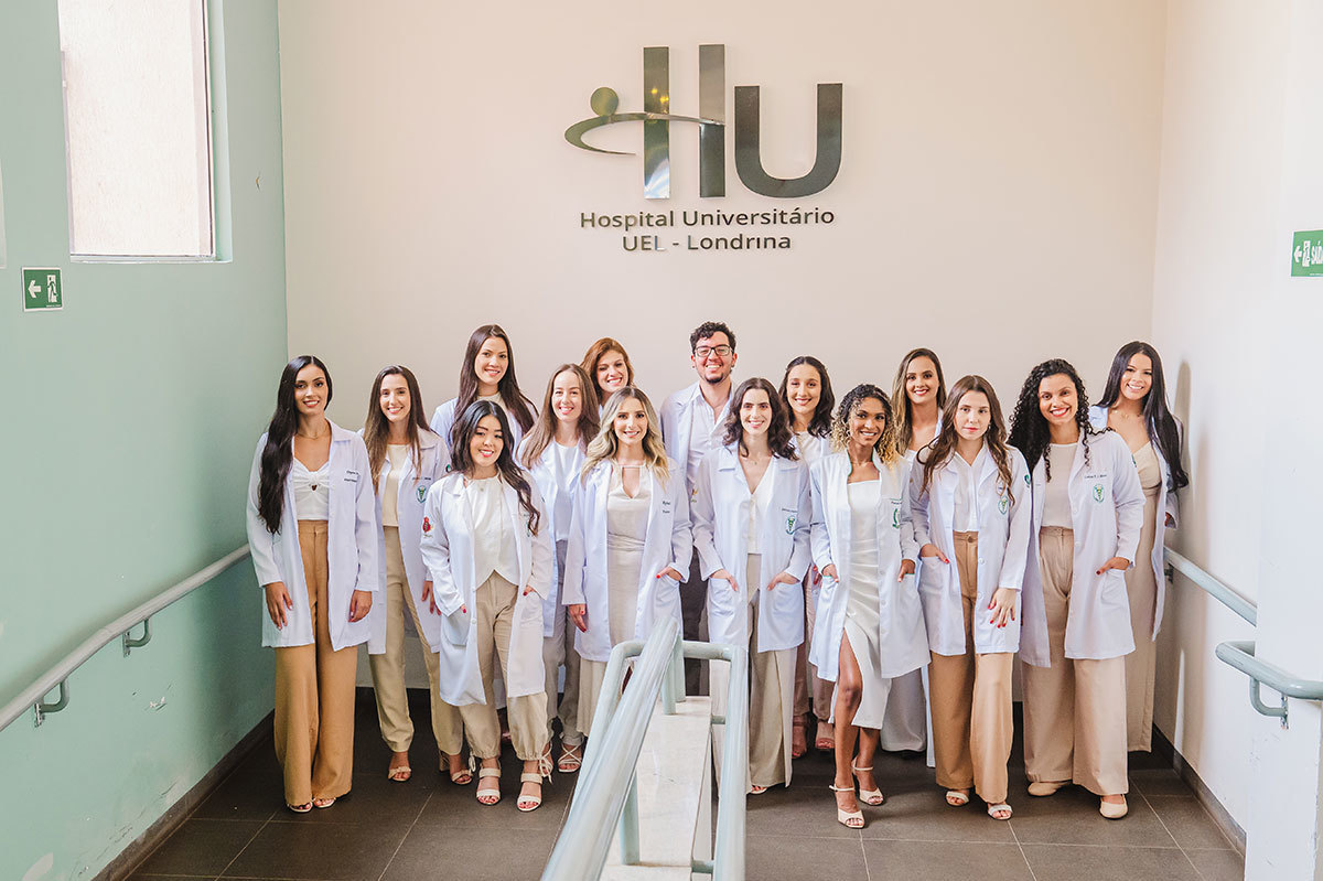 Foto da turma de fisioterapia em frente ao letreiro do Hospital Universitário de Londrina