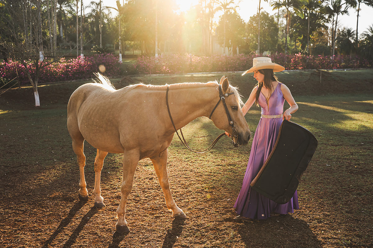 a aniversariante selando o seu cavalo de estimação
