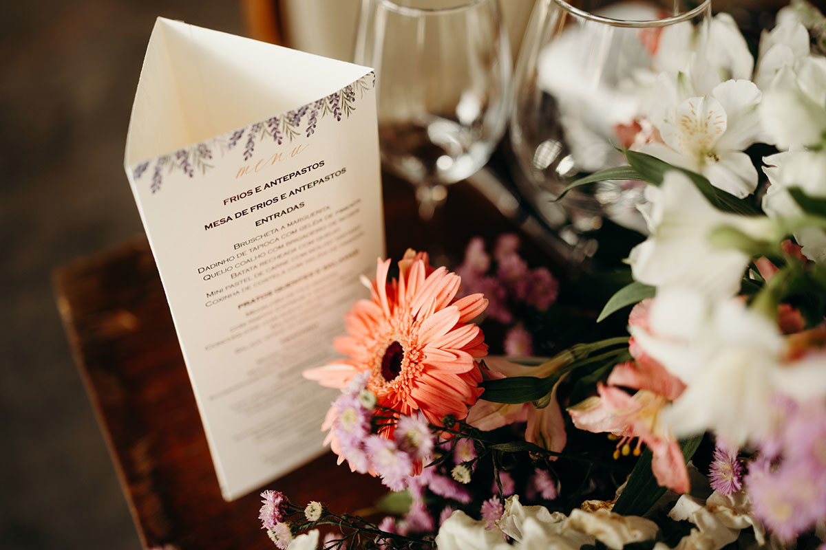 Menu da festa ao lado das flores
