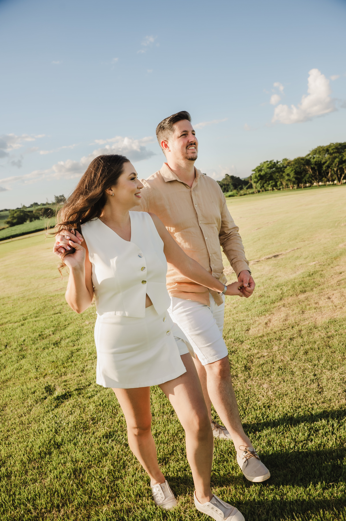Casal andando abraçados na grama