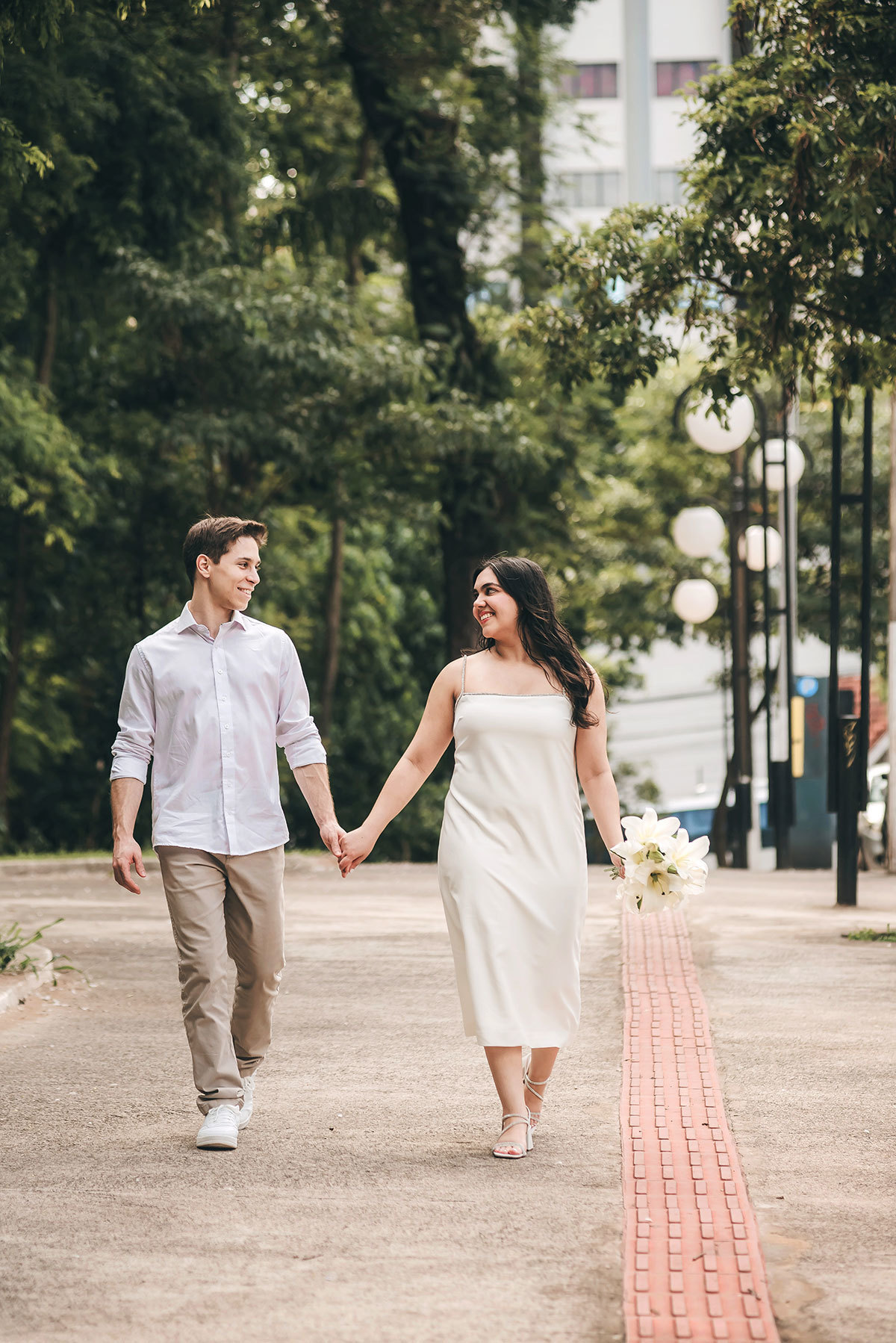 Noivos andando de mãos dadas na cidade após casamento no cartório