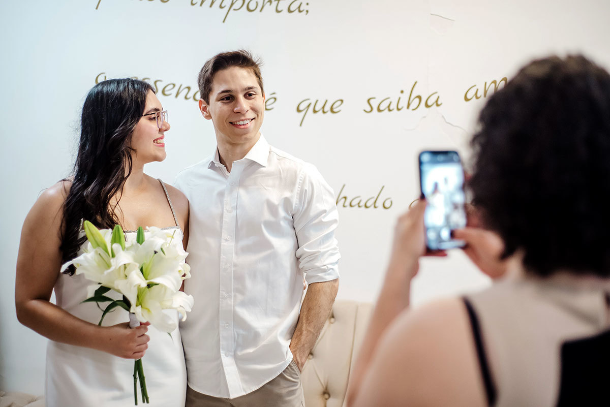 Noivos no cartório sendo fotografados pela madrinha