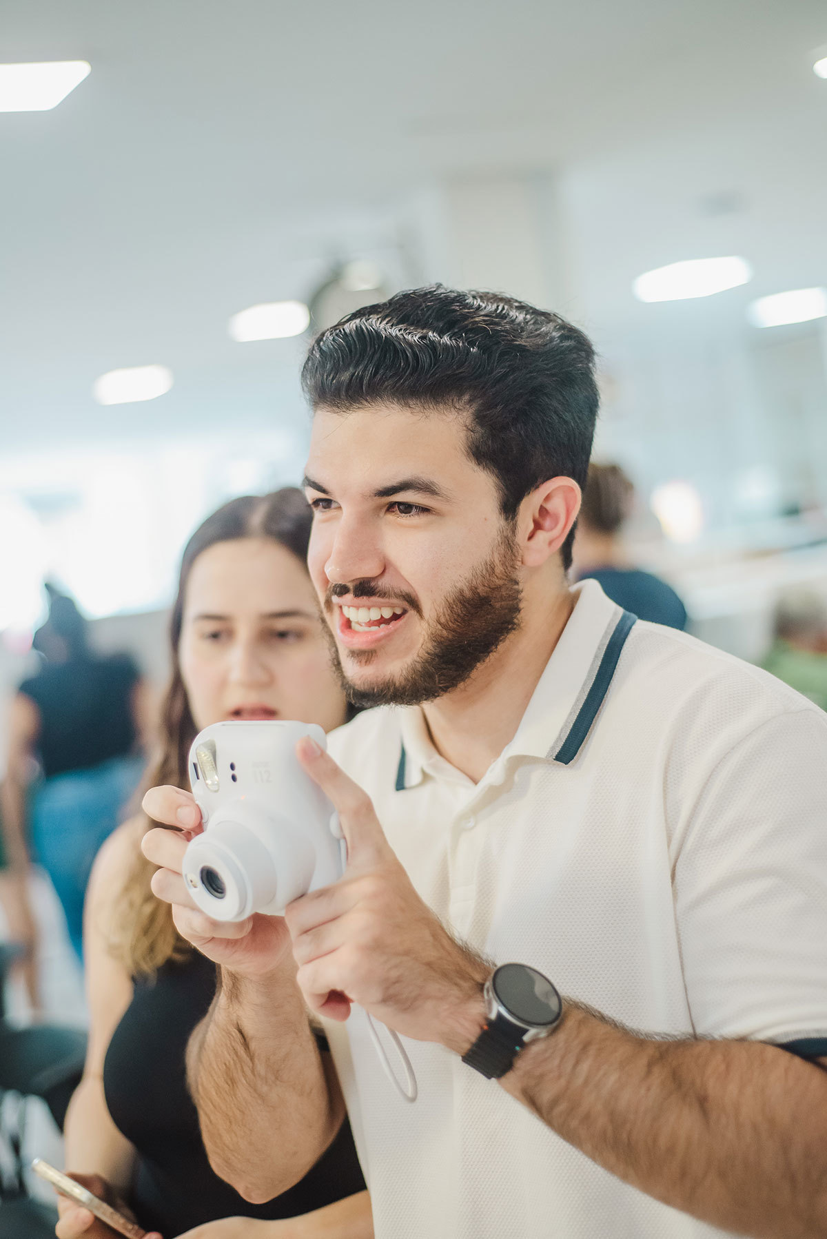 Padrinho com uma maquina de foto estantanea tirando foto dos noivos